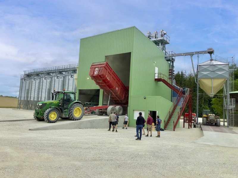 installation clé en main Agriconsult ciel bleu extérieur bâtiment photovoltaïque tracteur John Deere déchargement benne boisseau céréales grains silos cellules fond conique